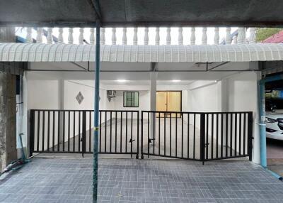 Spacious covered garage area with tiled flooring and secure gate