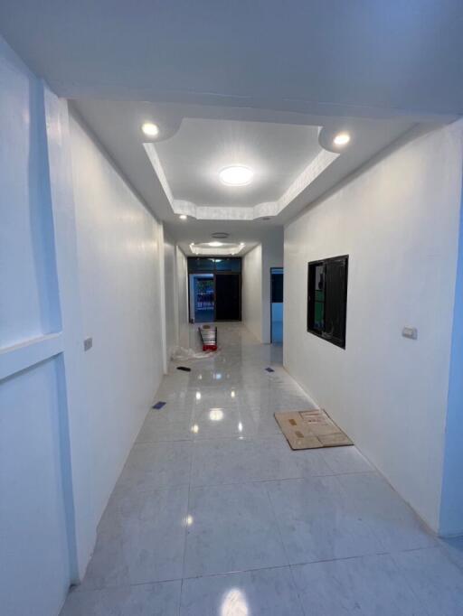 Modern white hallway with wall art and recessed lighting