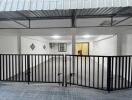 Spacious covered garage area with tiled flooring and secure metal gate