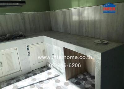 Spacious kitchen area with natural lighting and white cabinetry