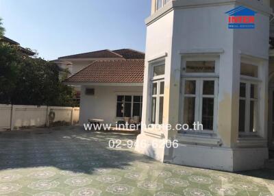 Exterior view of a spacious detached house with a tiled patio