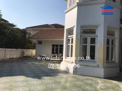 Exterior view of a spacious detached house with a tiled patio