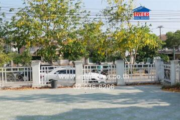 Gated entrance of a residential property with lush greenery