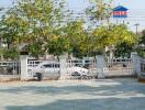 Gated entrance of a residential property with lush greenery