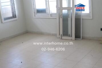 Spacious empty living room with large windows and balcony access