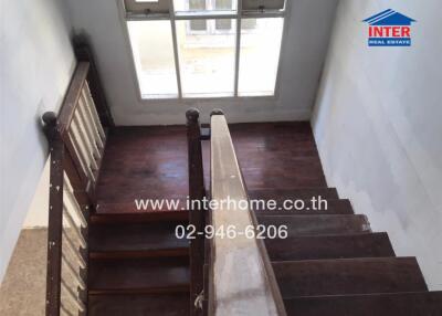 Wooden staircase with handrail leading to large window