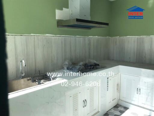 Spacious kitchen with modern amenities and green walls