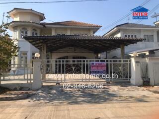 Front view of a two-story residential house with gated entrance