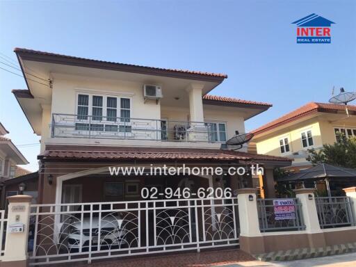 Spacious two-story residential house with balcony and gated entrance