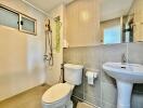 Modern bathroom with tiled walls and equipped with shower, toilet, and sink