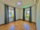 Bright and spacious unfurnished bedroom with large windows and hardwood flooring