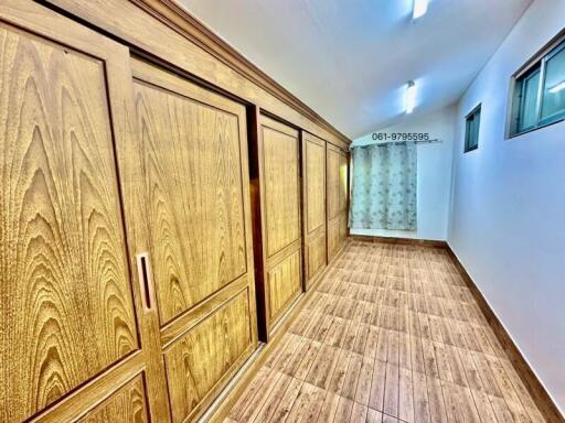 Spacious hallway with wooden wardrobe and tiled floor