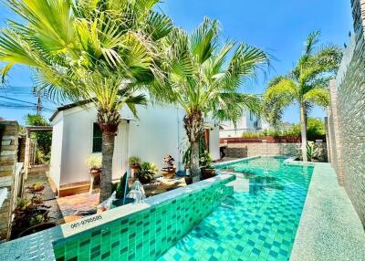 Lush tropical poolside with vibrant green landscaping and modern architectural features