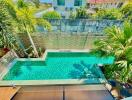 Aerial view of a beautiful residential outdoor swimming pool surrounded by lush greenery