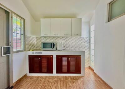 Bright and clean kitchen with upper cabinets and wooden floor