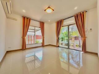 Spacious and bright living room with large windows and elegant curtains