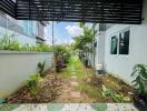 Spacious garden area with walkway and lush greenery next to a residential building