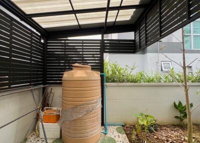 Covered patio space with water storage tank and garden