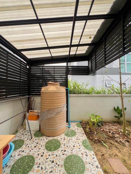 Covered patio space with water storage tank and garden