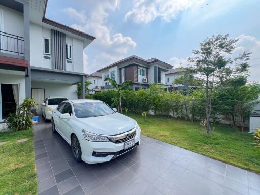 Spacious home exterior with manicured lawn and modern car parked