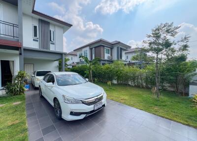 Spacious home exterior with manicured lawn and modern car parked