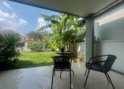 Spacious patio area with lush garden view and comfortable seating