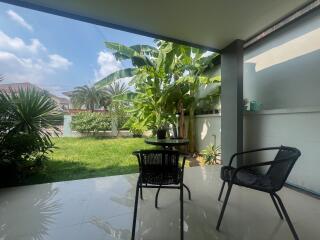 Spacious patio area with lush garden view and comfortable seating