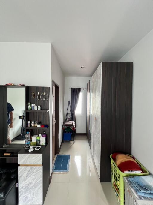 Interior view of a modern hallway with reflective floor tiles and wooden cupboards