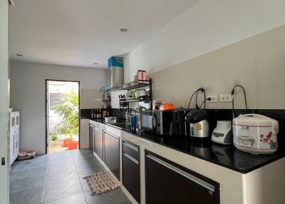 Modern kitchen with sleek cabinets and appliances leading to a bright patio