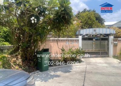 Front gate view of residential property with lush greenery