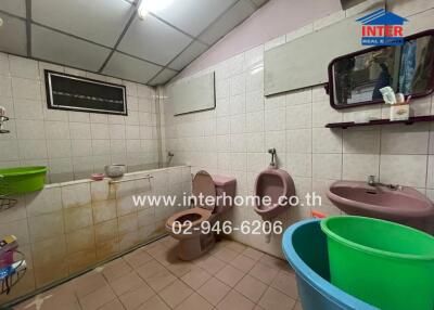 Spacious tiled bathroom with multiple fixtures