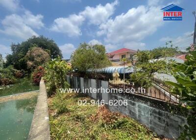 Outdoor view of a residential property showcasing a canal, lush greenery, and neighboring homes