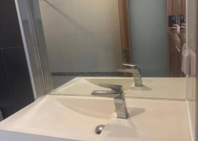 Modern bathroom interior with a reflective mirror and wooden door
