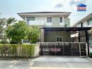 Modern two-story residential house with gated entrance and landscaped front yard