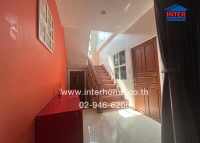 Bright hallway with red walls and staircase leading to the upper floor