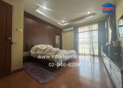 Spacious bedroom with large window and wooden furnishings