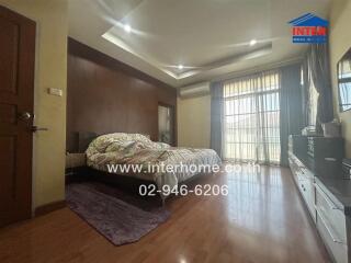 Spacious bedroom with large window and wooden furnishings