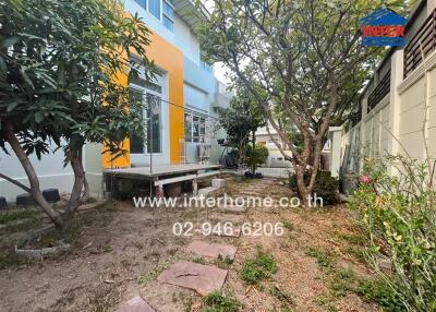 Vibrant two-story house exterior with a well-maintained garden