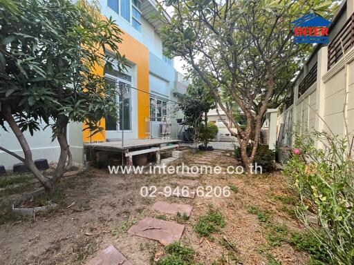 Vibrant two-story house exterior with a well-maintained garden