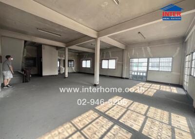Spacious empty interior of a building with large windows and ample natural light
