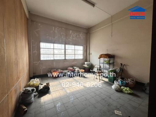 Spacious room in need of renovation with cluttered floor and natural light