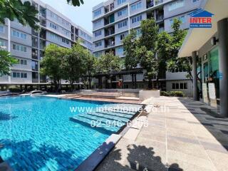 Modern residential complex with a large swimming pool and surrounding amenities