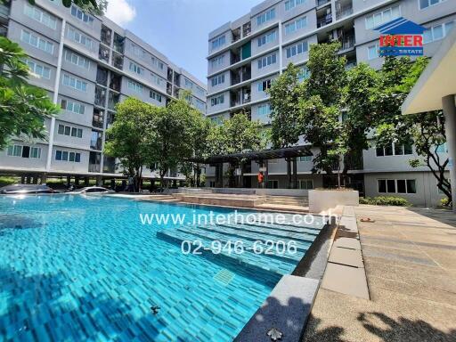 Inviting outdoor swimming pool area surrounded by building complex with ample greenery