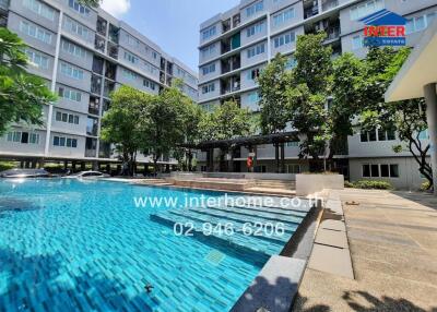 Inviting outdoor swimming pool area surrounded by building complex with ample greenery