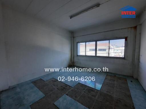 Empty room with tile floor and large window in an apartment