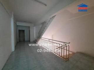 Spacious hallway with stairs and tile flooring