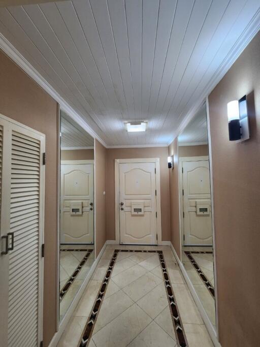 well-lit corridor with white paneled ceiling and tiled floor