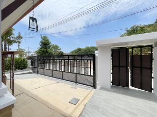 Spacious gated driveway with blue sky and ample parking space