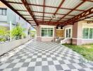 Spacious covered patio area with checkered floor and comfortable seating