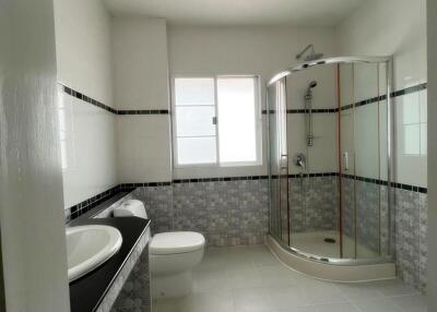Spacious modern bathroom with dual sinks and glass shower enclosure